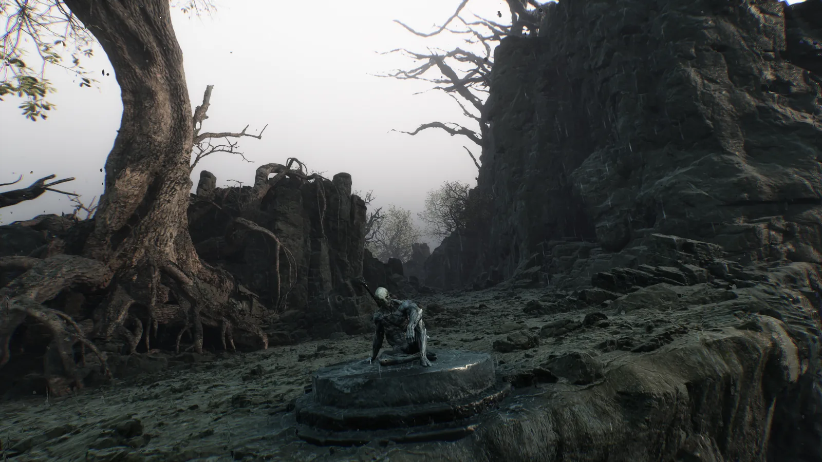Mortal Shell II screenshot: a pale, gaunt figure sits on a stone pedestal in a rain-soaked canyon between twisted trees and dark cliffs